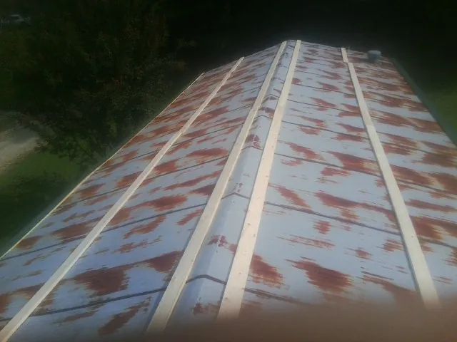 Rusted metal roof panels with new wood purlins before replacement — Storm Damage Roof Repair in Adolphus by Roofing Brothers