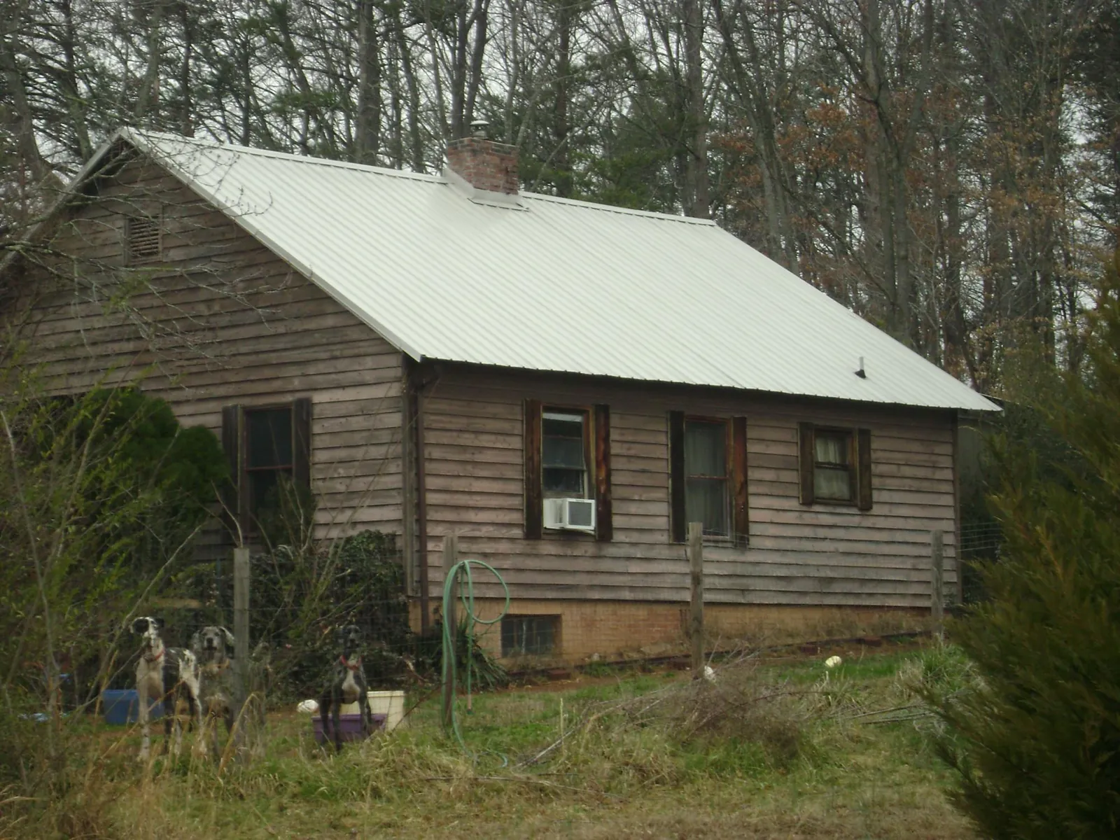White metal roof on an old wood sided farmhouse, from a Metal Roof Installation job in Adolphus